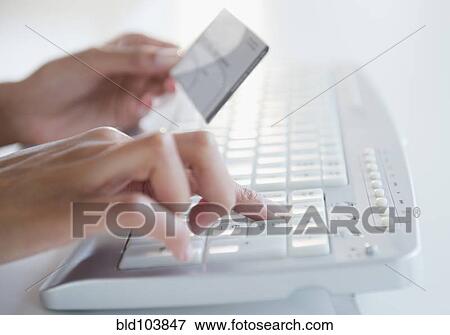 Stock Photo - Cape Verdean woman shopping online with credit card. Fotosearch