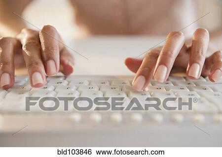 Stock Photograph - Cape Verdean woman typing on keyboard. Fotosearch