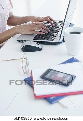 Stock Image - Cape Verdean woman using laptop. Fotosearch