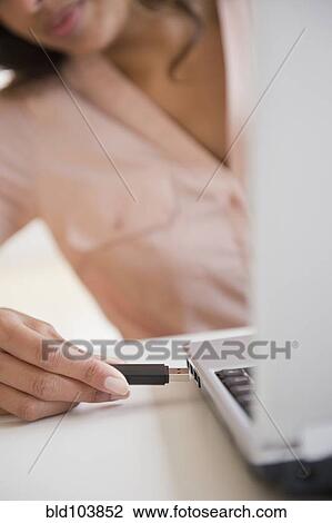Stock Image - Cape Verdean woman using USB device. Fotosearch