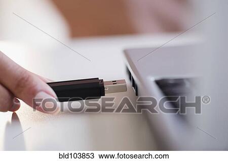 Stock Image - Cape Verdean woman using USB device. Fotosearch