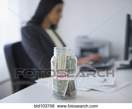 Stock Photograph - Cash in a jar marked 401k. Fotosearch