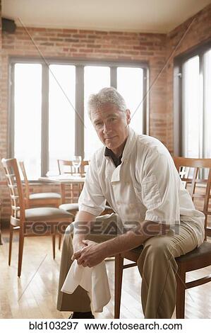 Stock Photo - Caucasian chef sitting in restaurant. Fotosearch