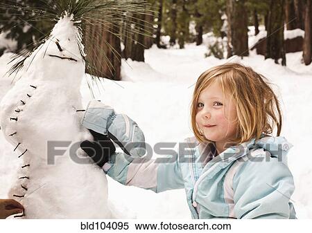 Stock Photography - Caucasian girl making strange snowman. Fotosearch
