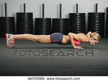 Picture - Caucasian woman doing push-ups. Fotosearch