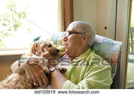 Stock Photo - Caucasian woman holding dog. Fotosearch