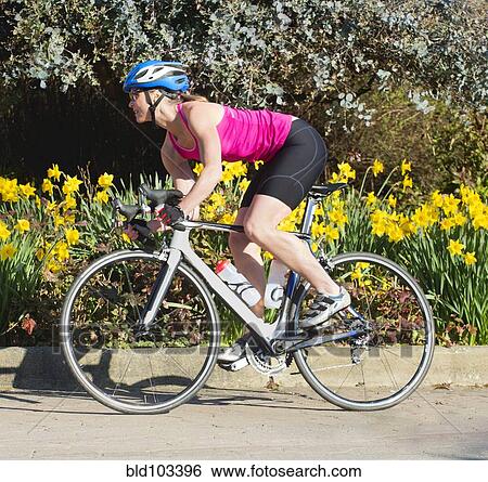 Stock Photograph - Caucasian woman riding bicycle. Fotosearch