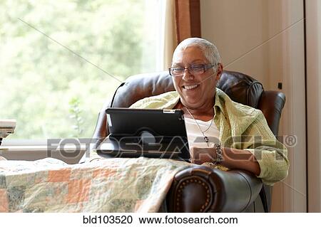 Stock Image - Caucasian woman using digital tablet. Fotosearch
