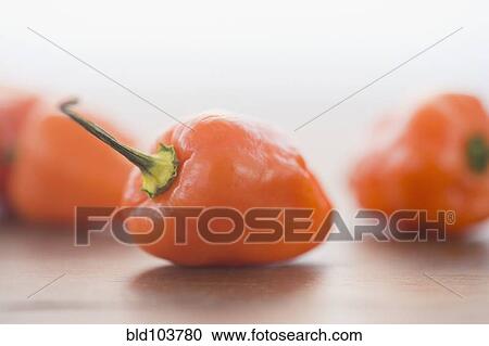 Stock Image - Close up of orange chili peppers. Fotosearch