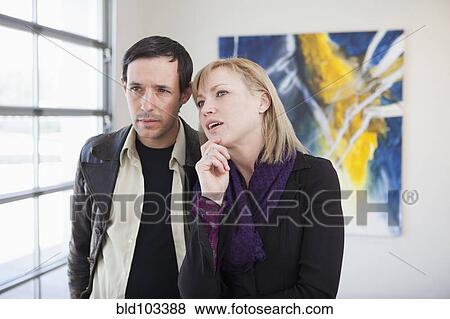 Stock Photo - Couple looking at art in art gallery. Fotosearch