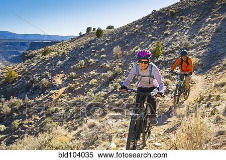 Couple mountain biking down hill View Large Photo Image Stock Photography - Couple mountain biking down hill. Fotosearch