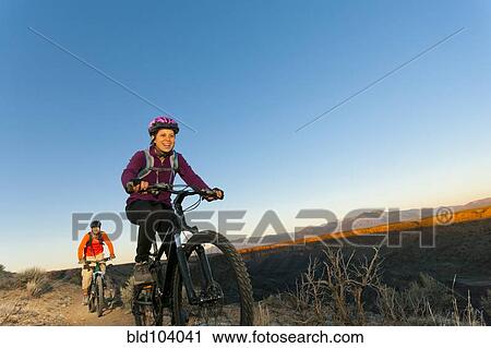 Couple mountain biking together View Large Photo Image Stock Image - Couple mountain biking together. Fotosearch
