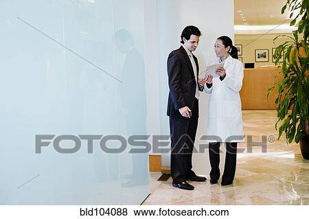 Stock Photo - Doctor and businessman using digital tablet. Fotosearch