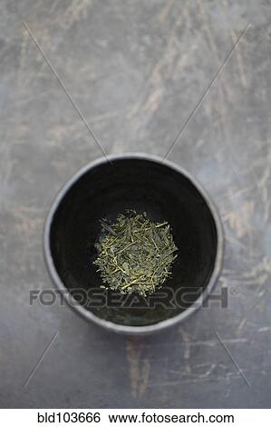 Stock Photograph - Dried sencha tea in tea cup. Fotosearch