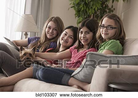 Friends hanging out on sofa together View Large Photo Image Stock Photo - Friends hanging out on sofa together. Fotosearch
