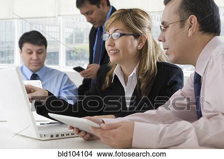 Picture - Hispanic business people working together. Fotosearch