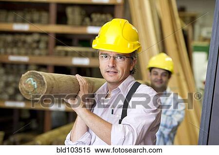 Stock Photography - Hispanic carpenters carrying lumber. Fotosearch
