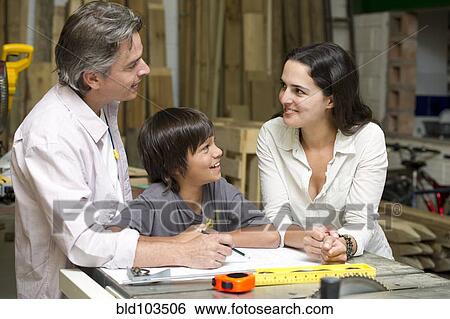 Stock Photograph - Hispanic family in carpentry workshop. Fotosearch