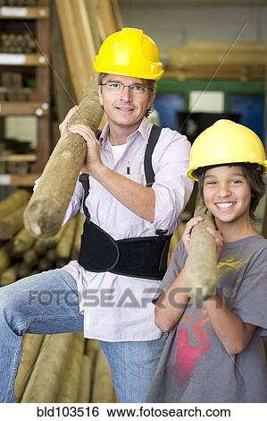 Stock Photograph - Hispanic father and son carrying lumber. Fotosearch