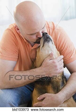 Stock Image - Man hugging and kissing dog. Fotosearch