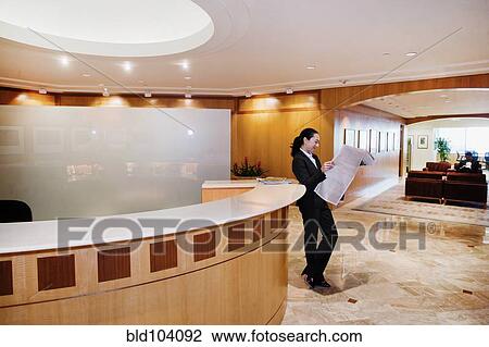 Mixed race businesswoman reading newspaper in office View Large Photo Image Stock Image - Mixed race businesswoman reading newspaper in office. Fotosearch