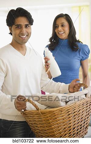 Stock Image - Mixed race couple doing laundry. Fotosearch
