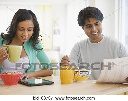 Stock Photo - Mixed race couple eating breakfast. Fotosearch
