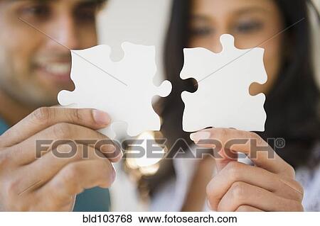 Mixed race couple holding puzzle pieces View Large Photo Image Stock Photo - Mixed race couple holding puzzle pieces. Fotosearch