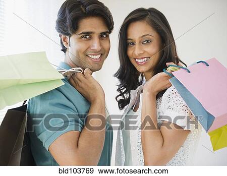 Mixed race couple holding shopping bags View Large Photo Image Stock Photo - Mixed race couple holding shopping bags. Fotosearch