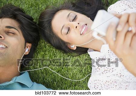 Mixed race couple listening to mp3 player together View Large Photo Image Stock Image - Mixed race couple listening to mp3 player together. Fotosearch