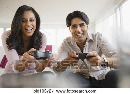 Stock Photo - Mixed race couple playing video game. Fotosearch