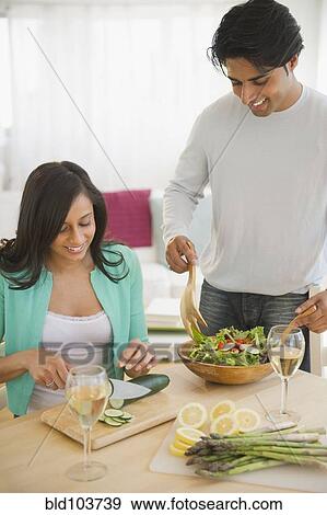 Stock Photo - Mixed race couple preparing salad. Fotosearch