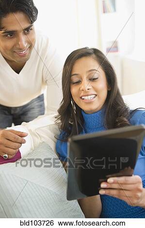 Stock Photograph - Mixed race couple using digital tablet. Fotosearch
