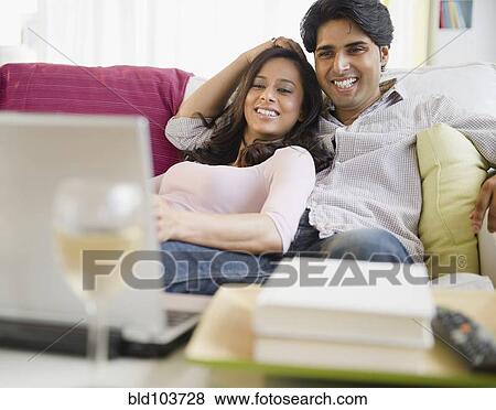 Mixed race couple watching television on laptop View Large Photo Image Stock Photo - Mixed race couple watching television on laptop. Fotosearch