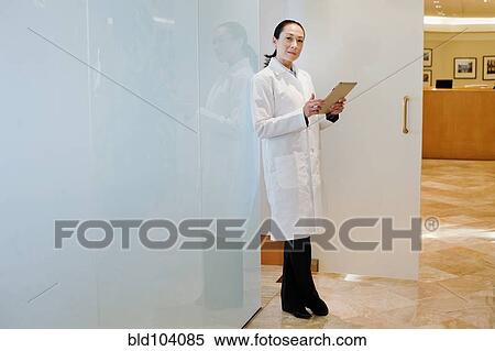 Stock Photography - Mixed race doctor using digital tablet. Fotosearch