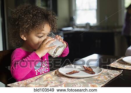 Stock Photo - Mixed race girl drinking milk. Fotosearch