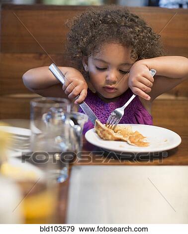 Mixed race girl eating breakfast in restaurant View Large Photo Image Stock Photo - Mixed race girl eating breakfast in restaurant. Fotosearch