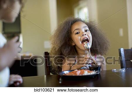 Mixed race girl eating dinner View Large Photo Image Stock Image - Mixed race girl eating dinner. Fotosearch