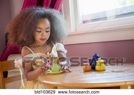 Mixed race girl having tea party View Large Photo Image Stock Photo - Mixed race girl having tea party. Fotosearch