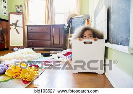 Mixed race girl hiding in hamper View Large Photo Image Stock Photo - Mixed race girl hiding in hamper. Fotosearch