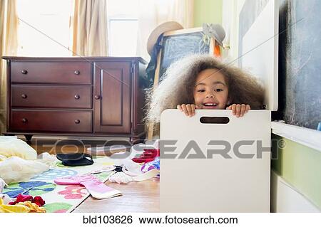 Stock Photograph - Mixed race girl hiding in hamper. Fotosearch