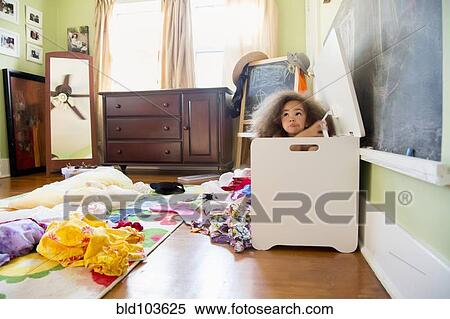 Stock Photography - Mixed race girl hiding in hamper. Fotosearch