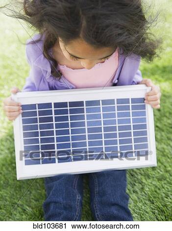 Mixed race girl holding solar panel View Large Photo Image Stock Image - Mixed race girl holding solar panel. Fotosearch