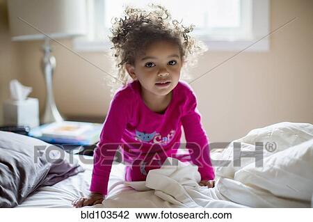 Mixed race girl kneeling on bed View Large Photo Image Stock Image - Mixed race girl kneeling on bed. Fotosearch