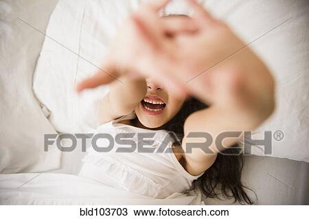 Stock Image - Mixed race girl laying in bed. Fotosearch