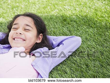 Mixed race girl laying in grass View Large Photo Image Stock Photo - Mixed race girl laying in grass. Fotosearch