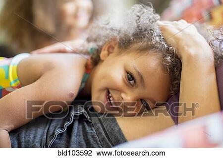 Mixed race girl laying on mother View Large Photo Image Stock Image - Mixed race girl laying on mother. Fotosearch