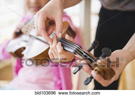 Stock Photograph - Mixed race girl learning to play violin. Fotosearch