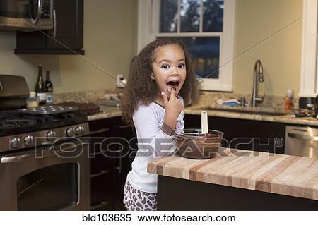 Stock Photography - Mixed race girl licking batter. Fotosearch
