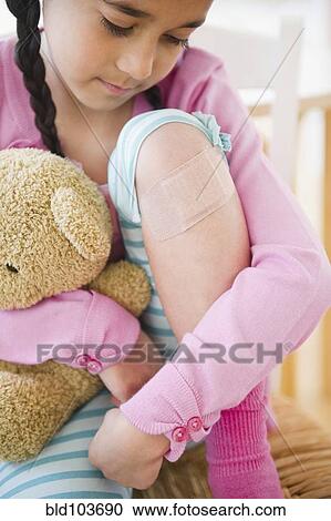 Mixed race girl looking at bandage on knee View Large Photo Image Stock Image - Mixed race girl looking at bandage on knee. Fotosearch